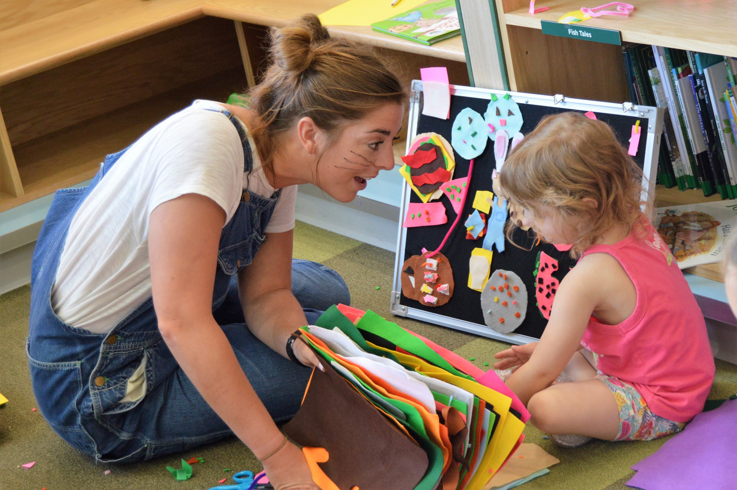 female volunteer interacts with young girl in activity zone.