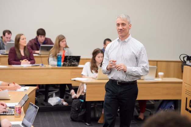 Professor teaches in front of class. 