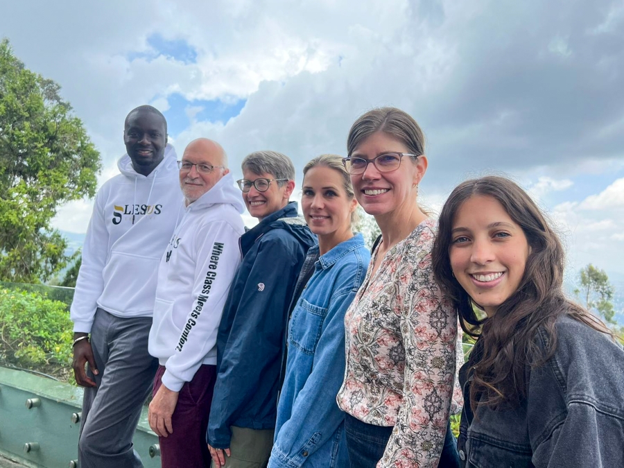 six professionals smile in front of a beautiful landscape