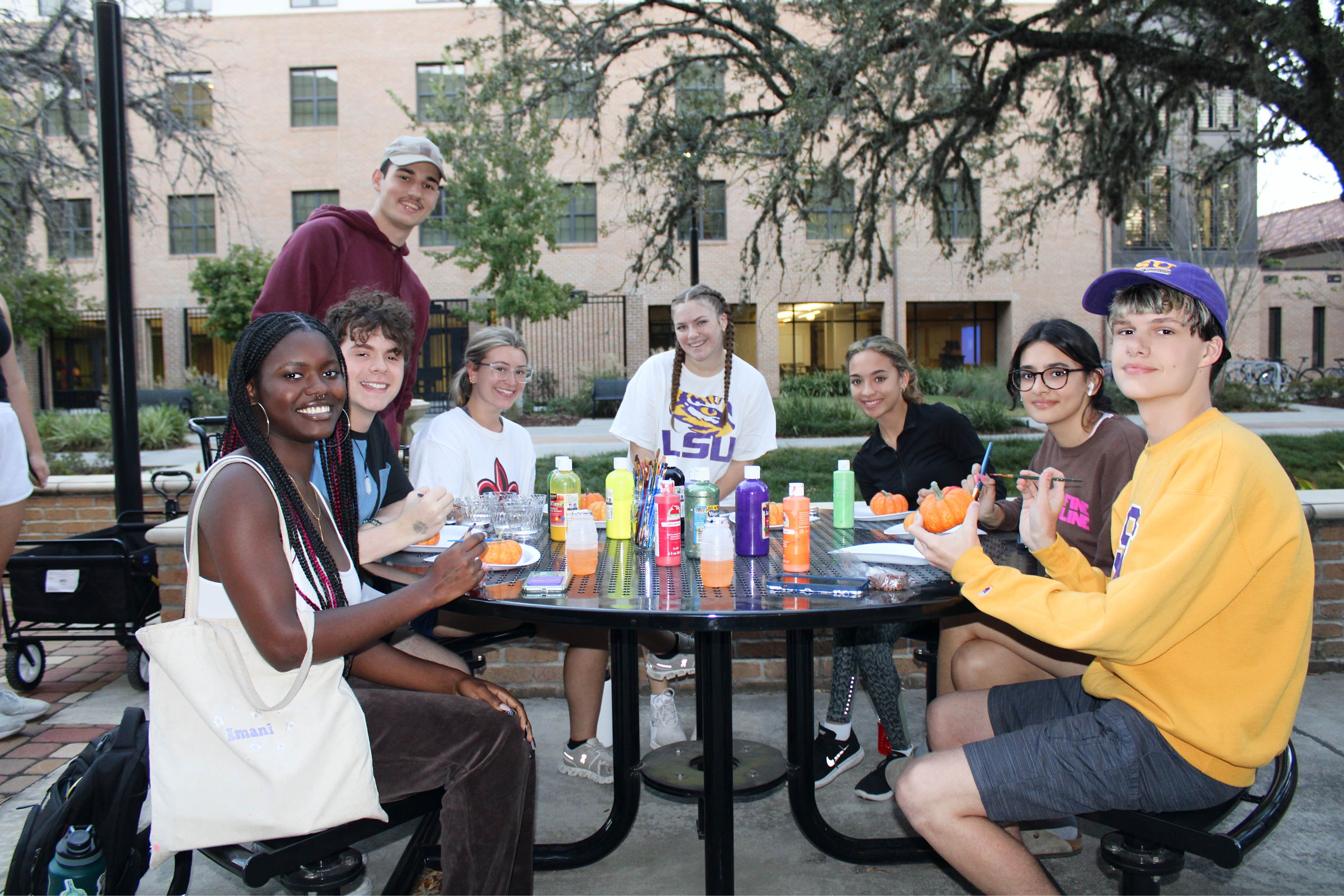 A group of students painting pumpkins at a Cedar Hall event.